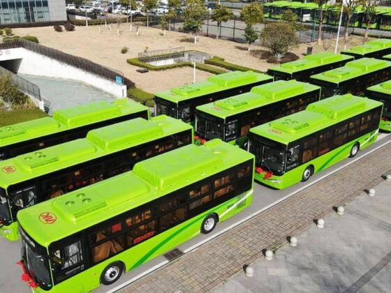 Fotografía de los nuevos autobuses de Nuevo León vistos lateralmente desde arriba, estacionados en una explanada. Son tres filas de autobuses, que van formados de izquierda a derecha. Todos los autobuses son color verde claro, con una franja verde más oscura en su lateral y ventanas oscuras.