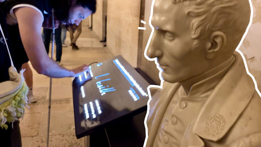 Foto de un busto de Louis Braille, visto de lado. Detrás se ve un módulo con información en braille y la firma del inventor en alto relieve. Un joven con baja visión toca el módulo.