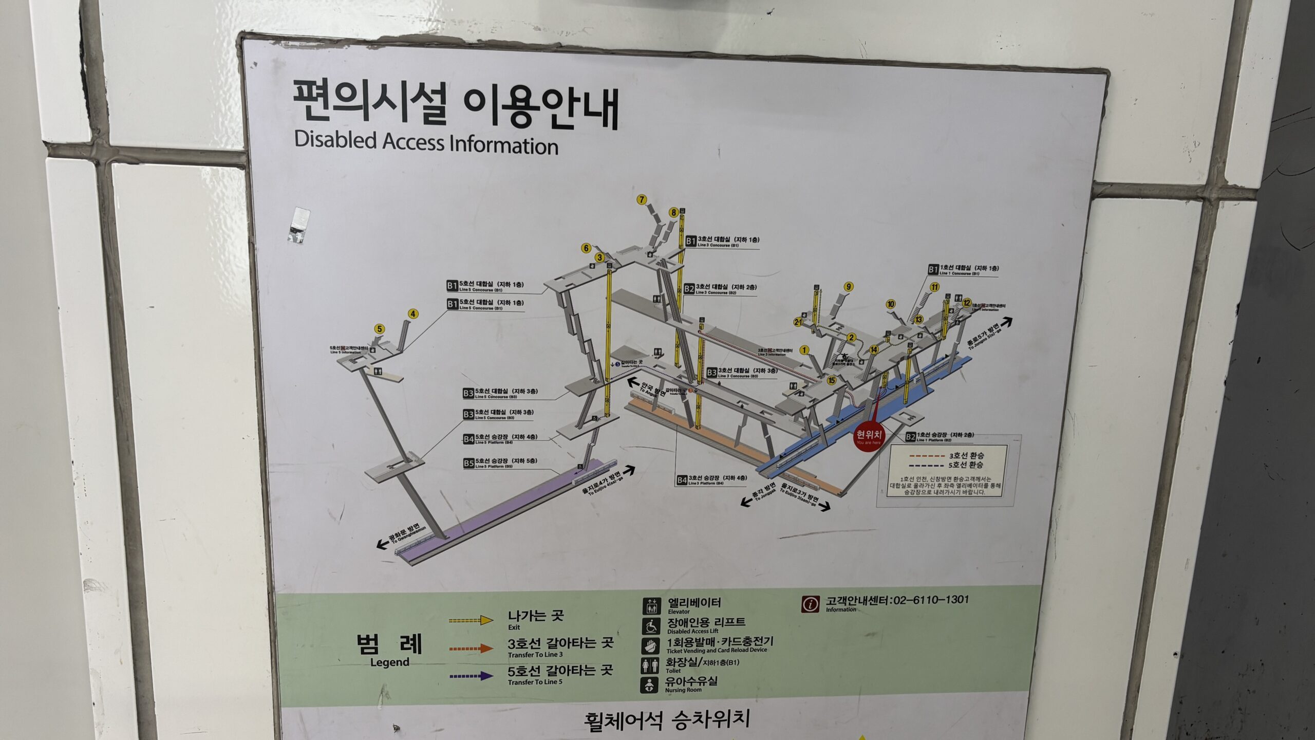 Fotografía de un cartel en el metro donde se muestra la ruta para llegar en silla de ruedas desde la entrada hasta el anden, que implica cambiar de elevador 3 veces en diferentes puntos del recorrido.