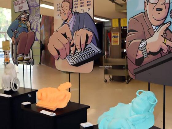 Fotografía de la exposición “los muros que derribamos” montada en una biblioteca, en el CCH Azcapotzalco. Se ven 3 pedestales con figuras impresas en 3D de personajes con discapacidad importantes a lo largo de la historia: Gilberto Rincón Gallardo, Louis Braille y Judith Heumann. Cada pedestal tiene también una ilustración en gran formato de cada personaje, cédulas en braille y bocinas donde se pueden escuchar sus respectivas audioguías.
